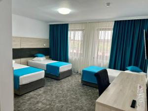 罗曼Hotel Bliss的酒店客房,设有两张床和蓝色窗帘