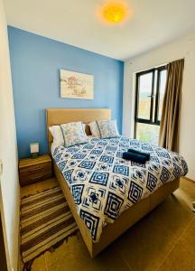 拉法洛维奇Sea Glass Sunset的一间卧室配有一张蓝色墙壁的床