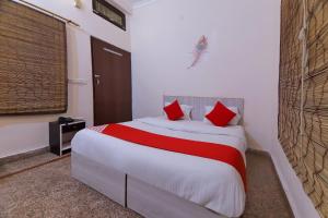 NarendranagarOYO Radhe Krishana Guest House的一间卧室配有一张带红色枕头的大床
