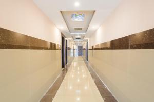 ĀsansolOYO Hotel Nakshatra.的拥有白色墙壁和天花板的建筑走廊
