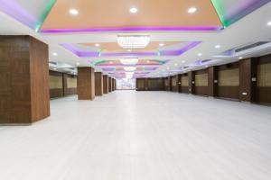 ĀsansolOYO Hotel Nakshatra.的一间铺有白色地板和紫色天花板的大大厅