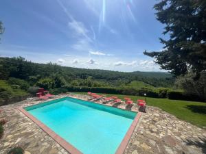Badia A PassignanoIl Fiorino di Badia的一个带椅子的游泳池,享有山景