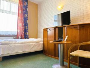 托日姆佩特罗汽车旅馆的一间卧室配有一张床、一台电视和一张桌子