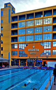 亚历山大New Siesta Hotel & Resort的大楼前的大型游泳池