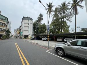 台南Triple One Entire Home 慶東111私人招待所 包棟民宿的棕榈树环绕的街道旁的停车场