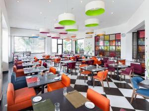 阿克拉阿克拉机场宜必思尚品酒店的餐厅设有桌椅和窗户。