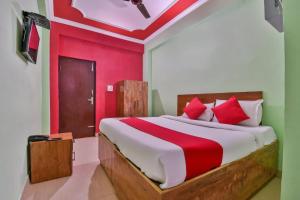 DīghaOYO Hotel Happy Journey的一间卧室设有一张带红色墙壁的大床