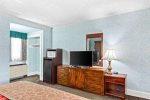 威廉斯堡罗德维历史酒店的卧室配有木质梳妆台上的平面电视。