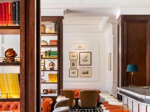 开普敦Cape Grace, A Fairmont Managed Hotel的客厅配有橙色椅子和书架