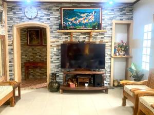 碧瑶Baguio mountain villa view RW的一间客厅,在砖墙上配有平面电视