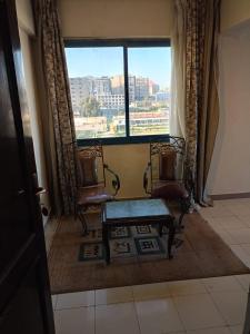 亚历山大New Siesta Hotel & Resort的窗户的房间里设有两把椅子和一张长凳