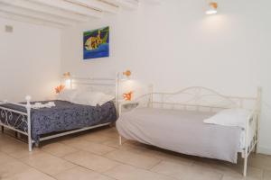 锡拉库扎Boutique Hotel Molo S Lucia的卧室设有2张床和白色的墙壁。