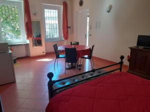 比耶拉"B&B Sans égal", con camere private e appartamenti al piano terra a Biella的客厅配有桌子和红色的床