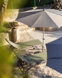 乌尔齐尼MASHTRA - The Olive House的庭院设有两把草坪椅和一把遮阳伞