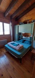 圣皮耶尔代勒福尔卡Logement cosy au pied des pistes的木制客房内的一间卧室配有一张大床