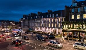 爱丁堡爱丁堡万豪万怡酒店的繁忙的城市街道,晚上有汽车和建筑