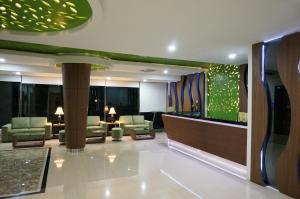 美娜多绿色伊甸园酒店的酒店大堂设有长沙发和椅子。