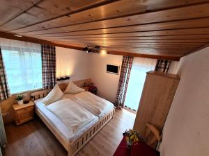 巴德哥依斯恩喜得乐旅馆的一间卧室设有一张床和木制天花板