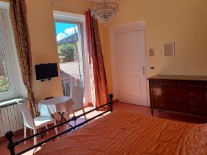 比耶拉"B&B Sans égal", con camere private e appartamenti al piano terra a Biella的一间卧室配有一张床、一张桌子和一个窗户。