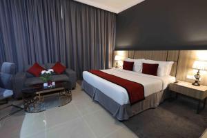 富查伊拉Fortis Hotel Fujairah的酒店客房设有一张大床和一张沙发。