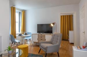 普雷斯顿Fulwood Heights Apartments的客厅配有电视、椅子和桌子