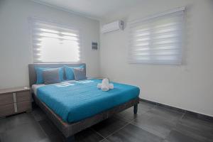 努尔德Casa Lima- Lovely Home Among All The Hotspots的一间卧室配有一张带蓝色毯子的床和两个窗户。
