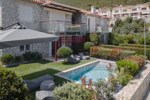 蒂洛斯Tyros Boutique Houses Villas的后院设有游泳池和遮阳伞