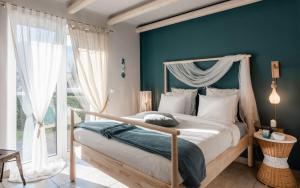 蒂洛斯Tyros Boutique Houses Villas的一间卧室设有天蓬床和蓝色的墙壁