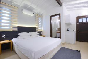 阿拉恰特AEGEAN Apartments - Bungalows的一间带白色大床的卧室和一间浴室