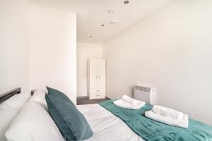 利物浦Modern 1 Bed Apartment in Bootle Liverpool的白色卧室配有一张带绿色和白色枕头的大床