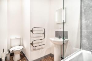 利物浦Modern 1 Bed Apartment in Bootle Liverpool的白色的浴室设有卫生间和水槽。