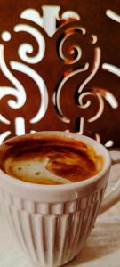 布哈拉Hotel Ansi Boutique W&S terrace的坐在桌子上喝杯咖啡