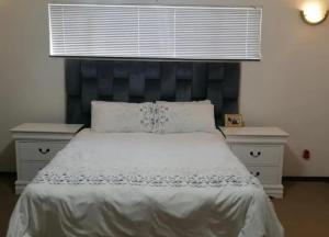 肯普顿帕克Lovely Holiday的一间卧室配有一张大床和蓝色床头板