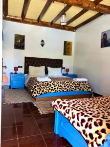 泰夫劳特雷尔葛妮尔迪迈尔酒店的一间卧室配有两张带猎豹床单的床