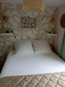 米米藏Mobil-home 6 personnes的卧室配有一张带白色枕头的床和壁纸
