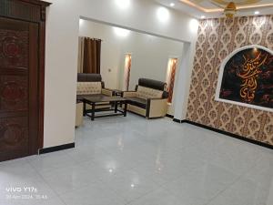 JhelumShah jee guest house的一间设有椅子和墙上一幅画的等候室