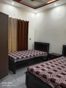 JhelumShah jee guest house的带两张床和窗帘的房间