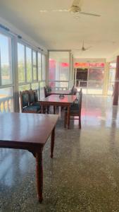 克久拉霍Goroomgo Hotel Casa Di William Khajuraho的用餐室设有桌椅和窗户。