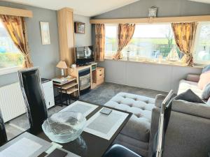 Saint CyrusWright Choice caravan rental 5 Lunan View St Cyrus Caravan Park的客厅配有沙发和桌子