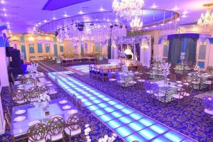 亚历山大New Siesta Hotel & Resort的宴会厅配有白色的桌椅和吊灯