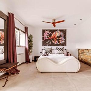 瓜达拉马Villa La Roca Madrid的卧室配有一张白色大床和吊扇。