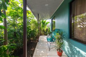 福尔图纳Vacation Home Bartenderluisch的一个带椅子和植物的蓝色房子的庭院