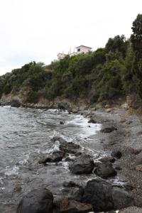 SoúrpiGoddesses Villa 1 in Nies的山丘上带房子的岩石海滩