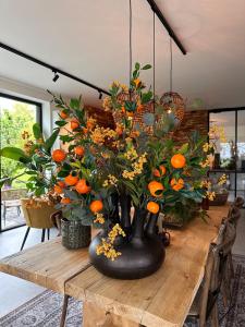 代尔夫特Hoeve BuytenHout的木桌上带橙子的黑色花瓶