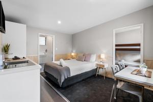 基督城Tasman Holiday Parks - Christchurch的一间卧室配有一张床,厨房配有水槽
