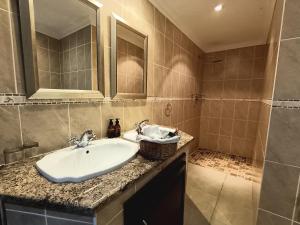 香槟谷Inkungu Lodge的一间带水槽和镜子的浴室