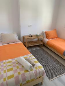 塞埃Picolo的一间设有两张床和一张小桌子的房间