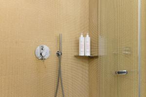 奥斯图尼Unico B&B Art Decor的瓷砖墙上的淋浴和2瓶