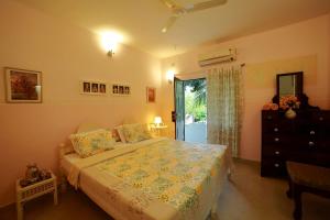 阿勒皮Bella Homestay Kerala的一间卧室配有一张床、一个梳妆台和一扇窗户。