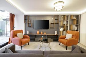 伊斯坦布尔Diamond Beyazit Hotel的客厅配有两把椅子和电视